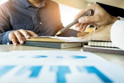Two people going over documents at a desk