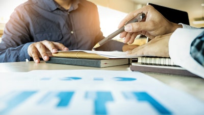 Two people going over documents at a desk