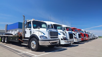 A line of multiple OEM used trucks parts on a lot