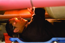 Technician under a truck working on a repair