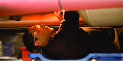 Technician under a truck working on a repair