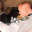 Kentucky vehicle inspector measuring brake components during inspection