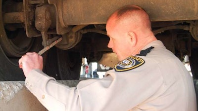 Kentucky vehicle inspector measuring brake components during inspection