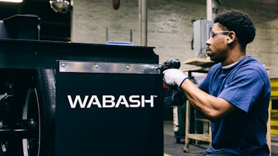A worker connects mudflaps with Wabash's new logo on a Duraplate dry van trailer