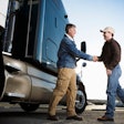 Customer shaking hands with truck sales rep.