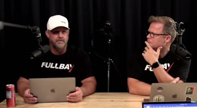 Chris O'Brien and Jacob Findlay speaking into microphones in a sound studio