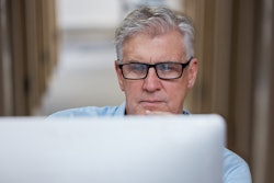 Veteran business owner researching customers on computer