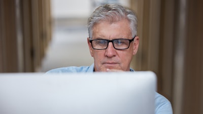 Veteran business owner researching customers on computer