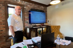 Allen Phibbs standing behind a desk in an office
