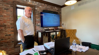 Allen Phibbs standing behind a desk in an office