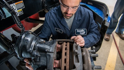 Bendix technician inspecting wheel-end components.