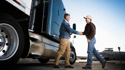 Customer shaking hands with sales person.
