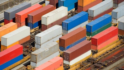 Photo of containers stacked two high in a busy railyard