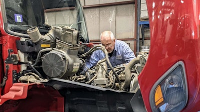 H.K. Truck Center technician working on a truck engine.