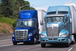 Two blue trucks on the highway