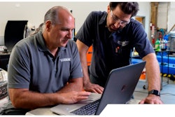 Dorman instructing training a truck technician on a laptop.