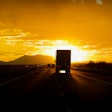 Truck driving into sun