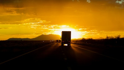 Truck driving into sun