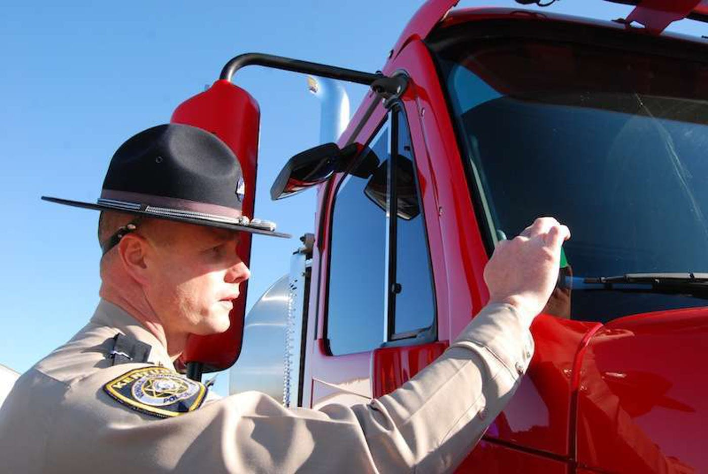 Inspector placing CVSA decal on truck