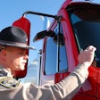 Inspector placing CVSA decal on truck