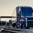 Mack Anthem blue exterior on roadway by rails