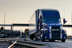 Mack Anthem blue exterior on roadway by rails
