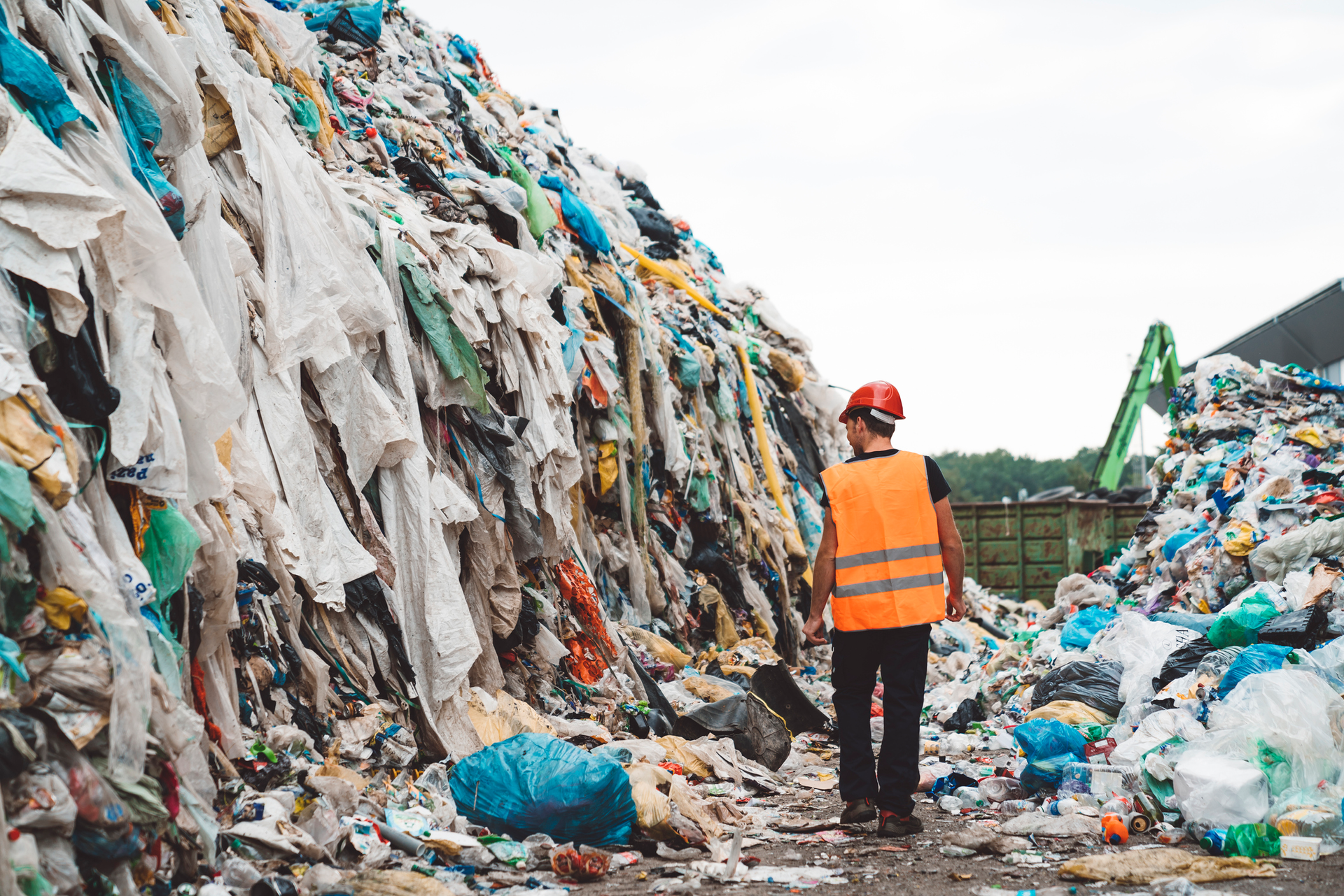 man walking through a landfill