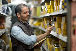 Man in warehouse counting yellow boxes