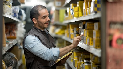 Man in warehouse counting yellow boxes