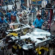People working at a vehicle assembly line.