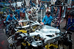 People working at a vehicle assembly line.