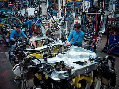 People working at a vehicle assembly line.
