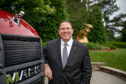 Jonathan Randall stands next to a red Mack truck.