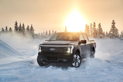 Ford F-150 Lightning Alaska in snow with trees and the sun in the background