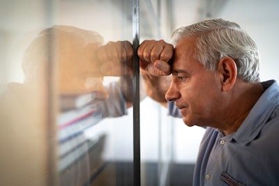 Frustrated man in an office looking at wall