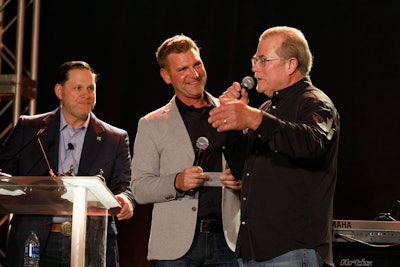 Three men. on a stage with microphones