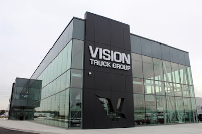 Picture of a glass and metal building with a Vision Truck Group sign.