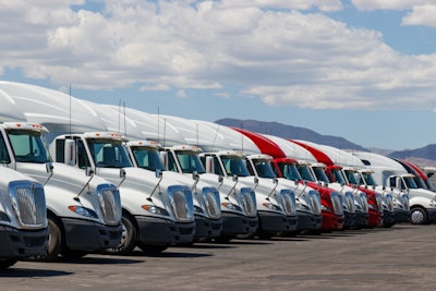 A line of Class 8 trucks on a lot.