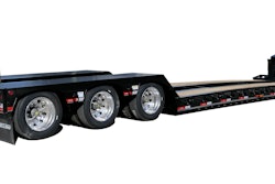 A gooseneck trailer, as seen from behind, with an oversize load sign.