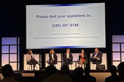 A group of people seated onstage at a conference.