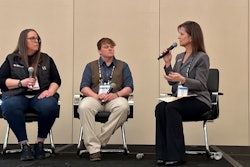 Three women on stage with microphones.