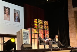 Three people on stage at a conference.