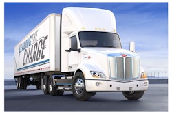 A white Peterbilt 579 EV Class 8 truck with a trailer that reads 'Leading the Charge.'
