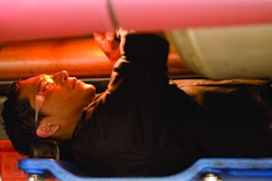 Technician under a truck working on a repair
