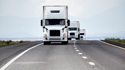 Trio of white trucks on highway