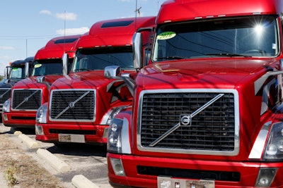 A line of red trucks for sale.