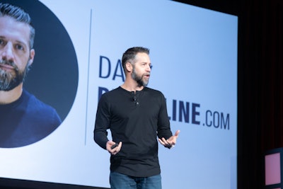 A man standing on stage speaking.