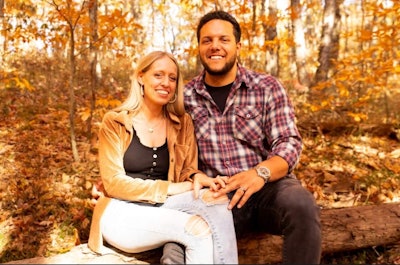 A man and a woman against a fall background.