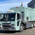 A mint green Mack LR Electric refuse truck at Bruckner Truck Sales in Commerce City, Colorado.