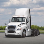 A white Class 8 truck on a tarmac.